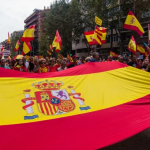 Primer plano de banderas de España durante una manifestación civil contra las concesiones políticas del Gobierno de la nación.
