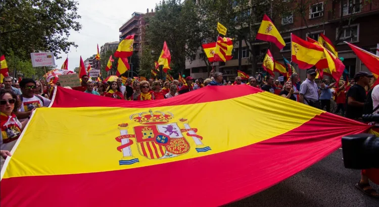 Primer plano de banderas de España durante una manifestación civil contra las concesiones políticas del Gobierno de la nación.