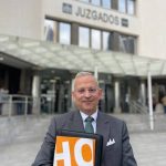 Javier Pérez Roldan con carpeta de HO ante unos juzgados
