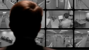 Un operario en una oficina vigilando decenas de pantallas digitales y televisión.