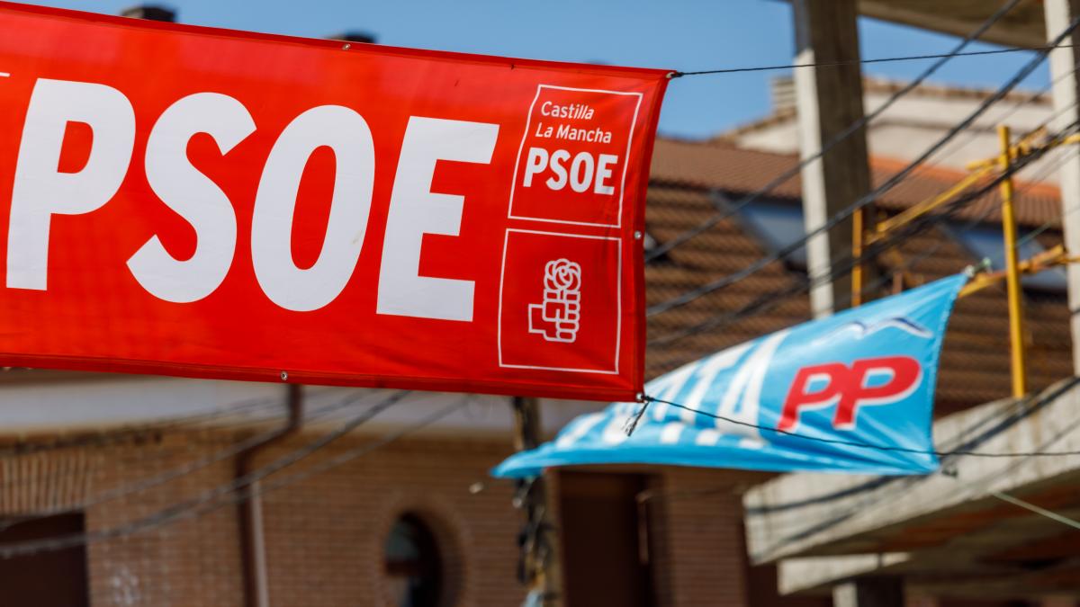 Lonas del Partido Popular y del Partido Socialista Obrero Español ondeando juntas en un evento l político.