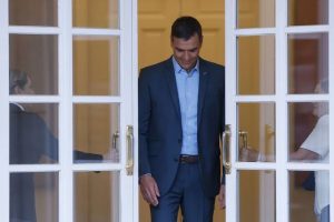 Sánchez saliendo de la moncloa y dos personas le abren las puerats