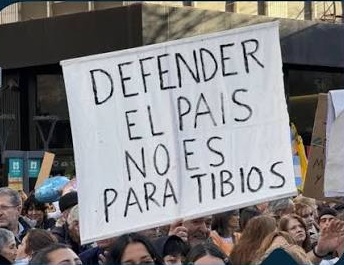 pancarta en una manifestación que dice: "Defender el país no es para tibios"